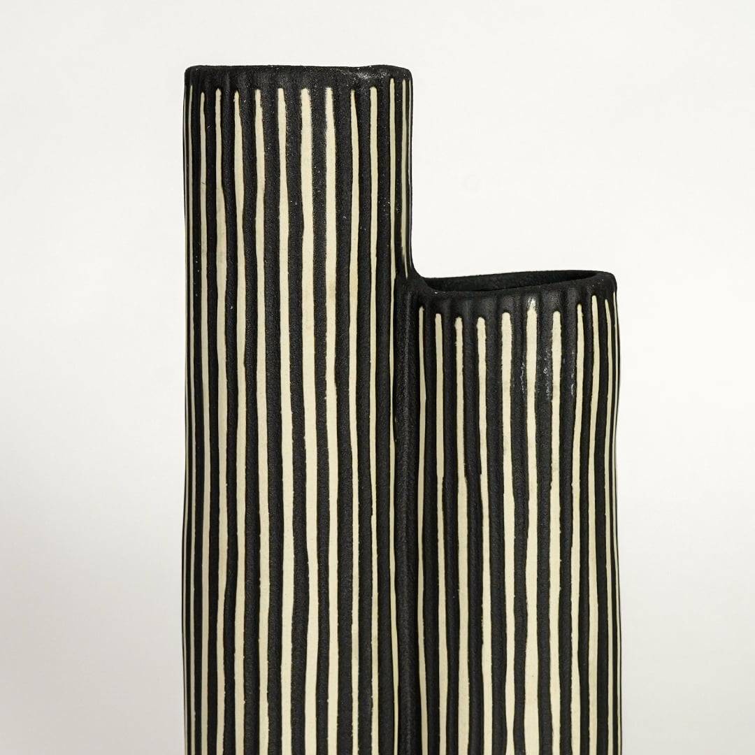 Detailed top view of black striped ceramic vase showing twin openings and handcrafted ribbed surface.