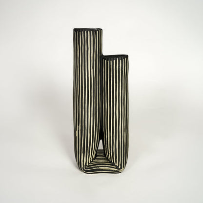 Modern black ceramic dual opening vase with striped texture ideal for console styling and home decor display.