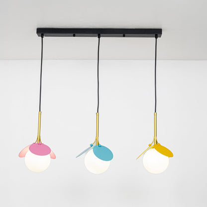 Pastel pink blue and yellow pendant light with frosted globes shown against a white background highlighting its modern playful shape with lights switched on.