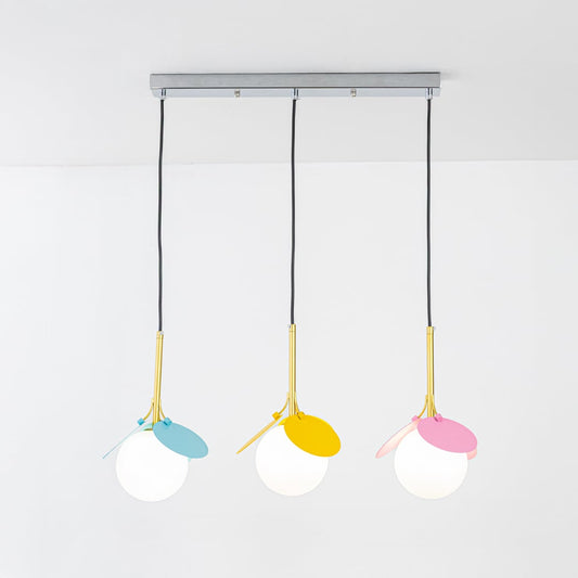 Warm glowing white globe pendant lights with colorful blue yellow and pink petals and gold stems displayed on a bright white background for decor styling.