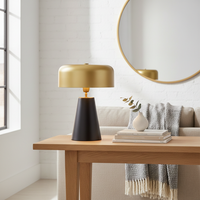 Table lamp styled on a wooden console in a modern living room with sofa mirror soft throw and decor creating a warm cozy ambient setting.