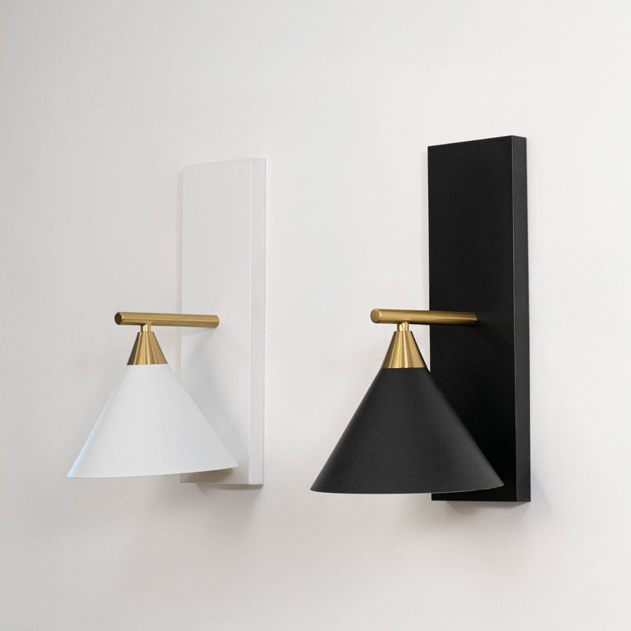 Collection of stylish black triangular shade wall sconces with brass gold hardware displayed off on clean white backdrop.