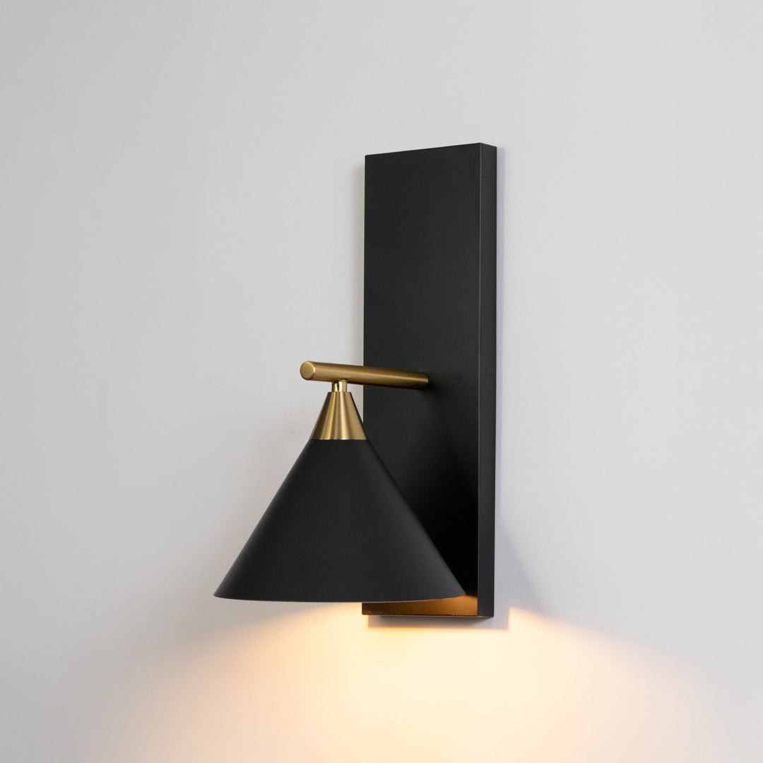 Black metal cone wall light on white background with warm downward lighting for modern hallway wall decor.