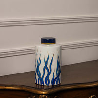 Elegant handcrafted white ceramic jar with blue and gold pattern ideal for tabletop and home interior decoration.