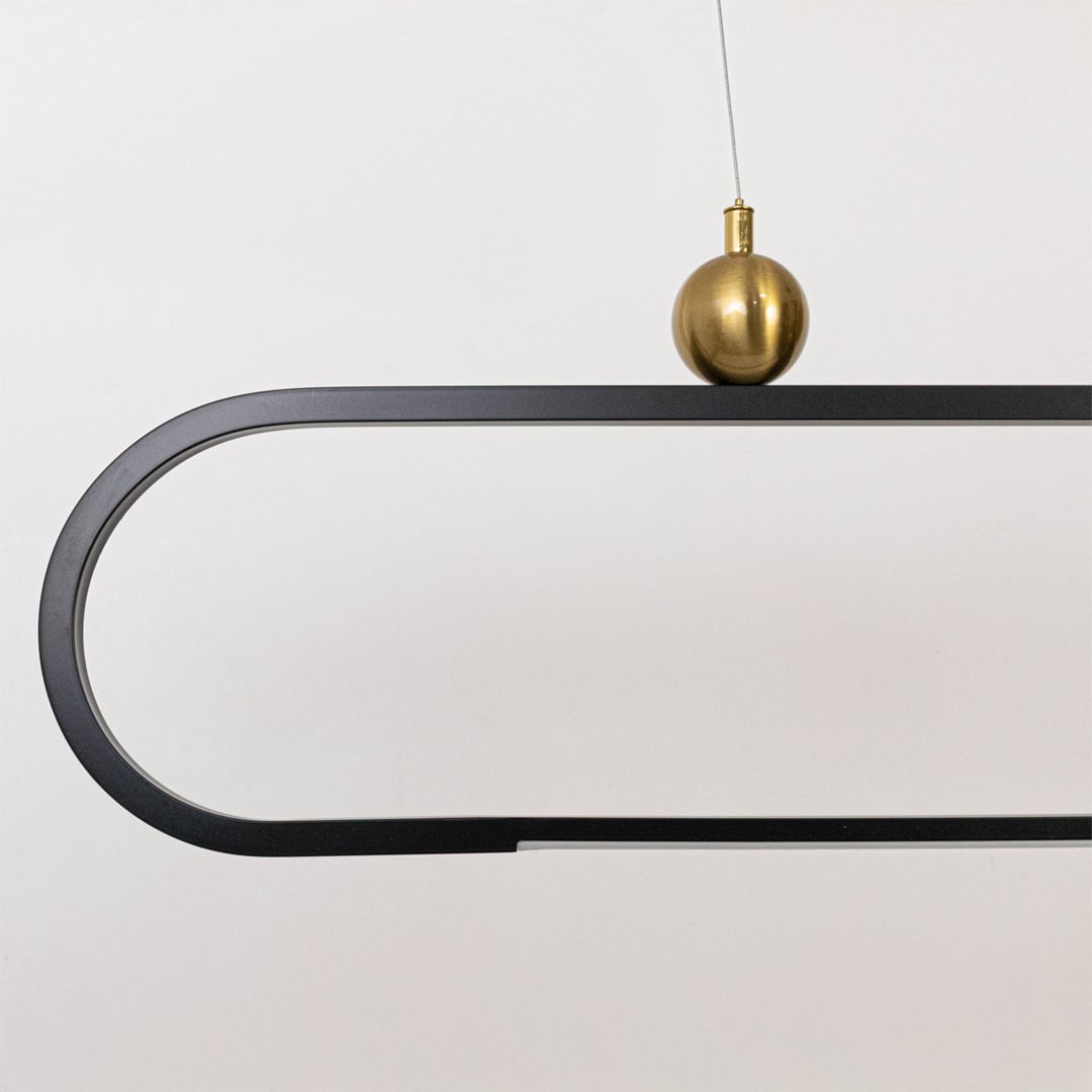 Closeup view of the modern chandelier highlighting its smooth metal frame and elegant gold spheres for a refined minimal look.