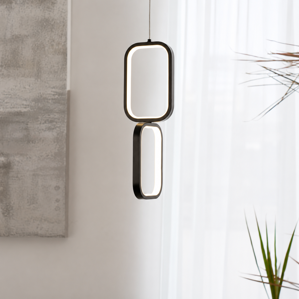 A modern double-light pendant lamp with a black metal frame and glowing white LED light, hanging in a minimalist room setting with a concrete wall and sheer white curtains.