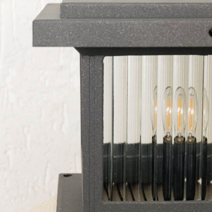 Closeup of black outdoor gate light with ribbed glass panels for elegant exterior decor styling use.