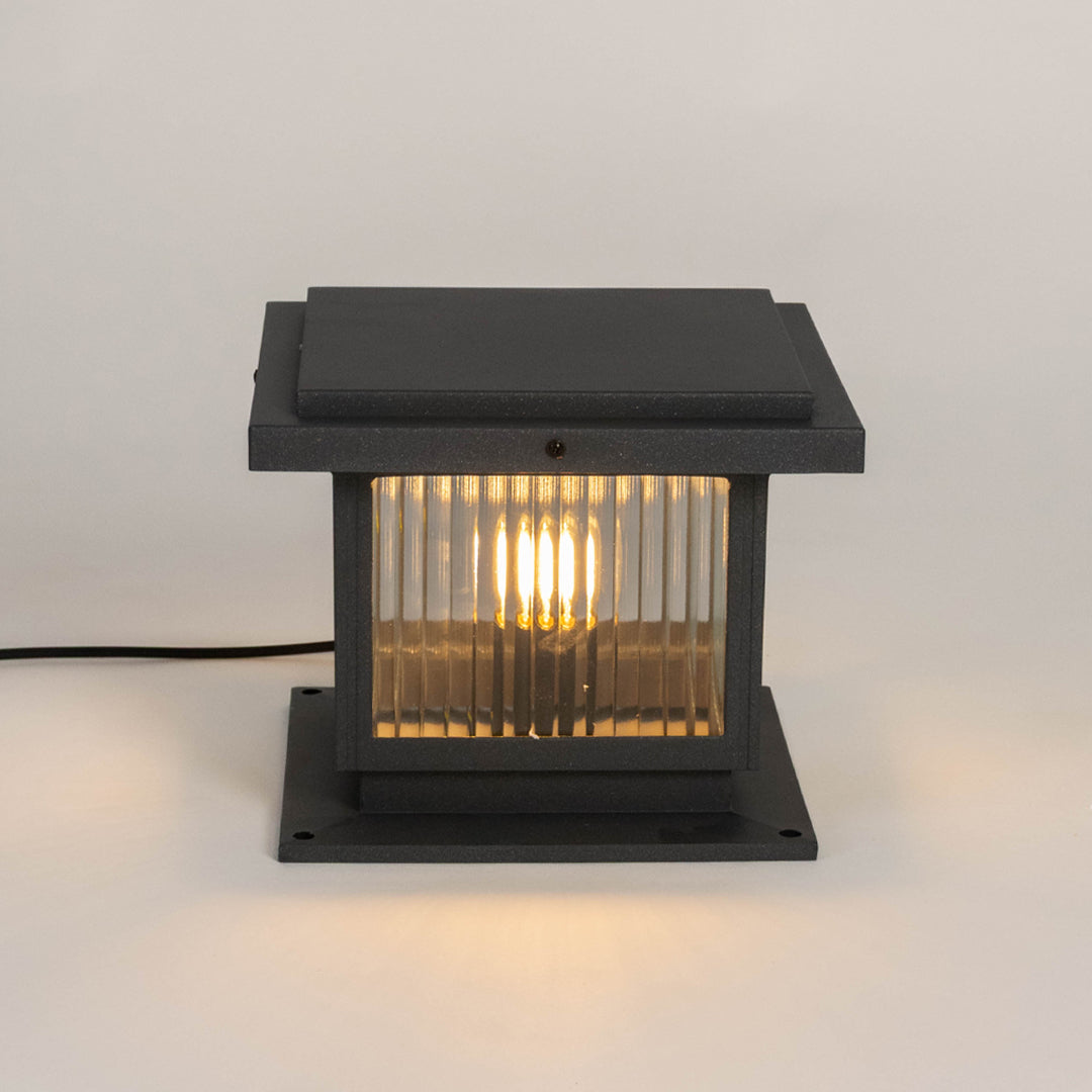 Black outdoor gate light with warm glowing bulb for elegant modern exterior decor styling use.