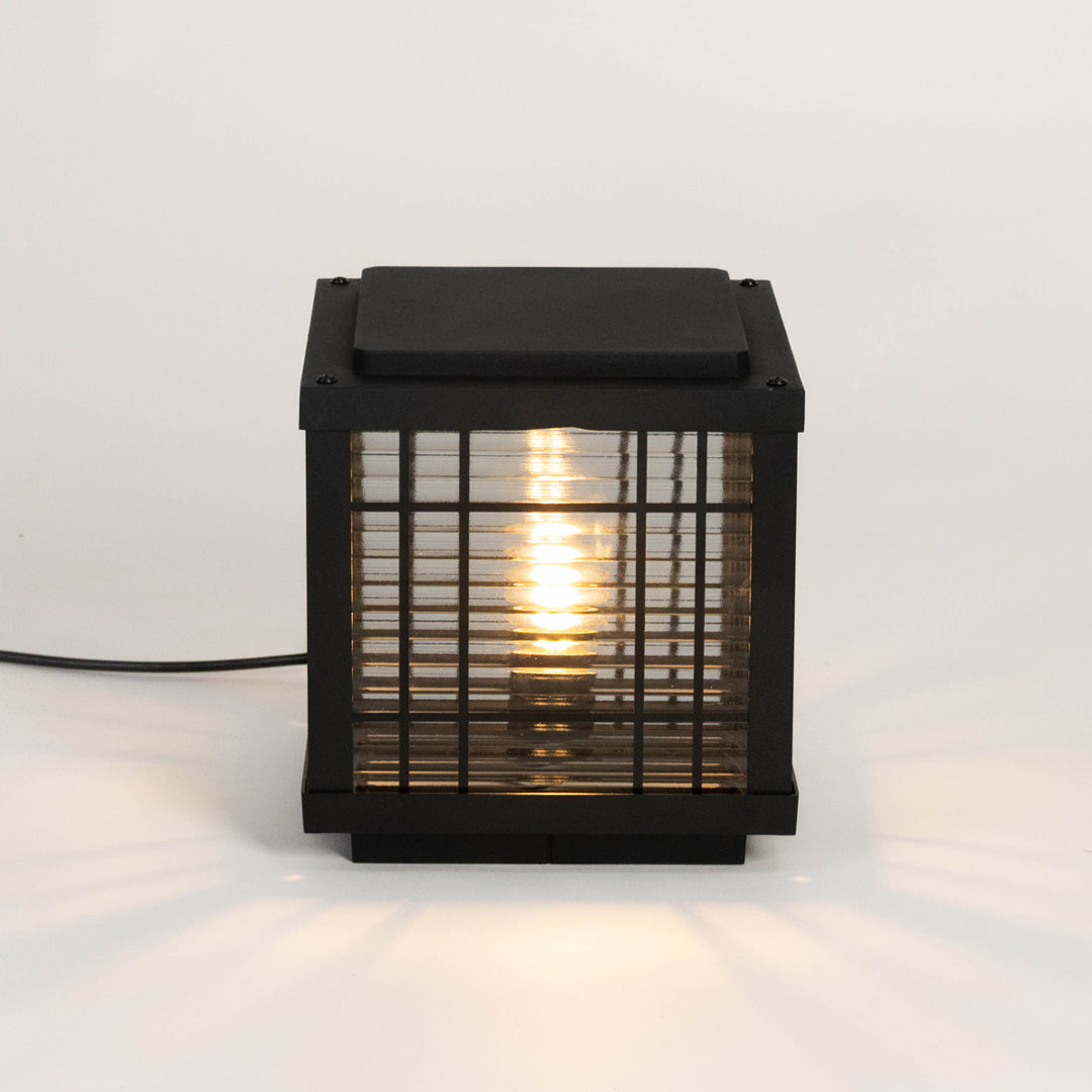 Black outdoor gate light with warm glowing bulb for elegant modern exterior decor styling use.