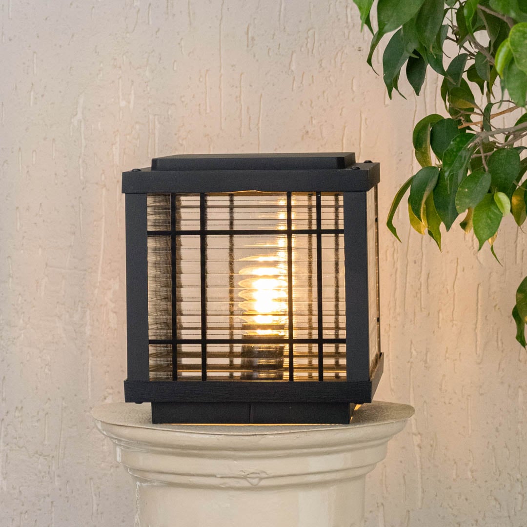 Outdoor black metal pillar lamp with frosted glass detail and LED bulb design for durable garden and patio lighting.