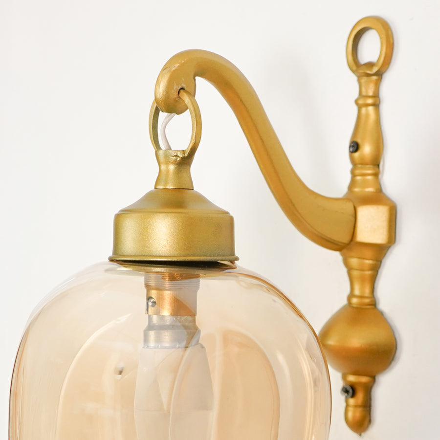 Closeup image of brass cast downward wall light for elegant modern living room decor styling highlighting smooth finish.