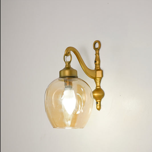 White background image of illuminated brass cast downward wall light for elegant modern living room styling and lighting.