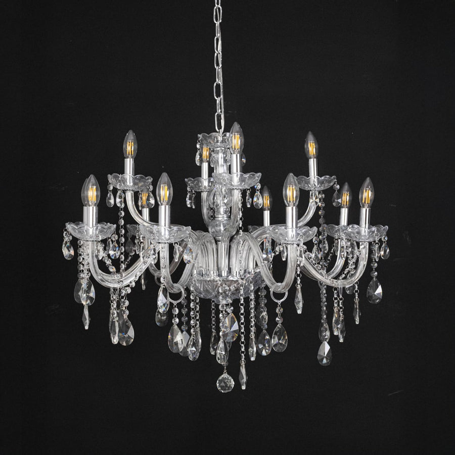 Crystal chandelier with glass arms and crystal drops turned off on black background display for decor view.
