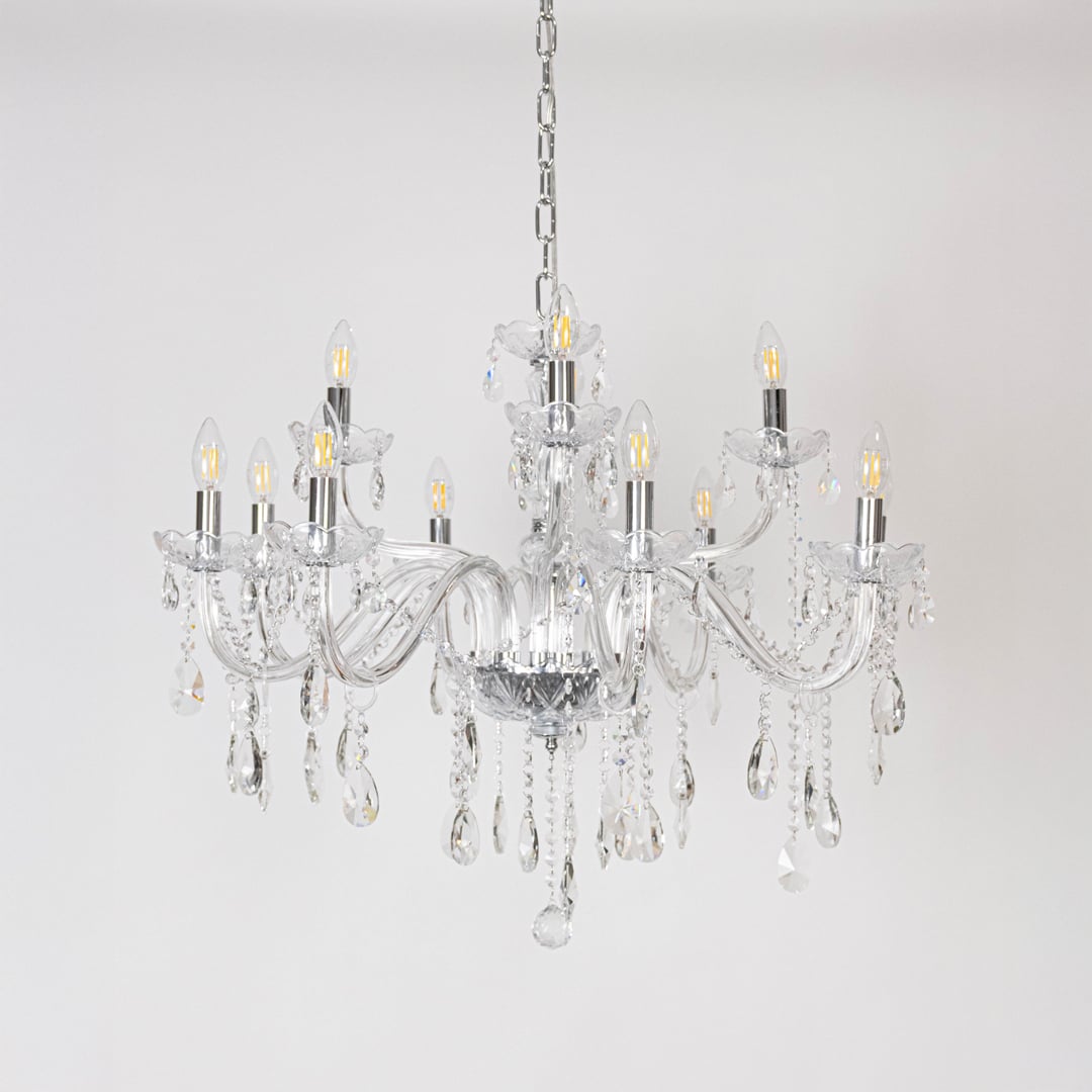 Crystal chandelier with glass arms candle lights and crystal drops turned off on white background decor.