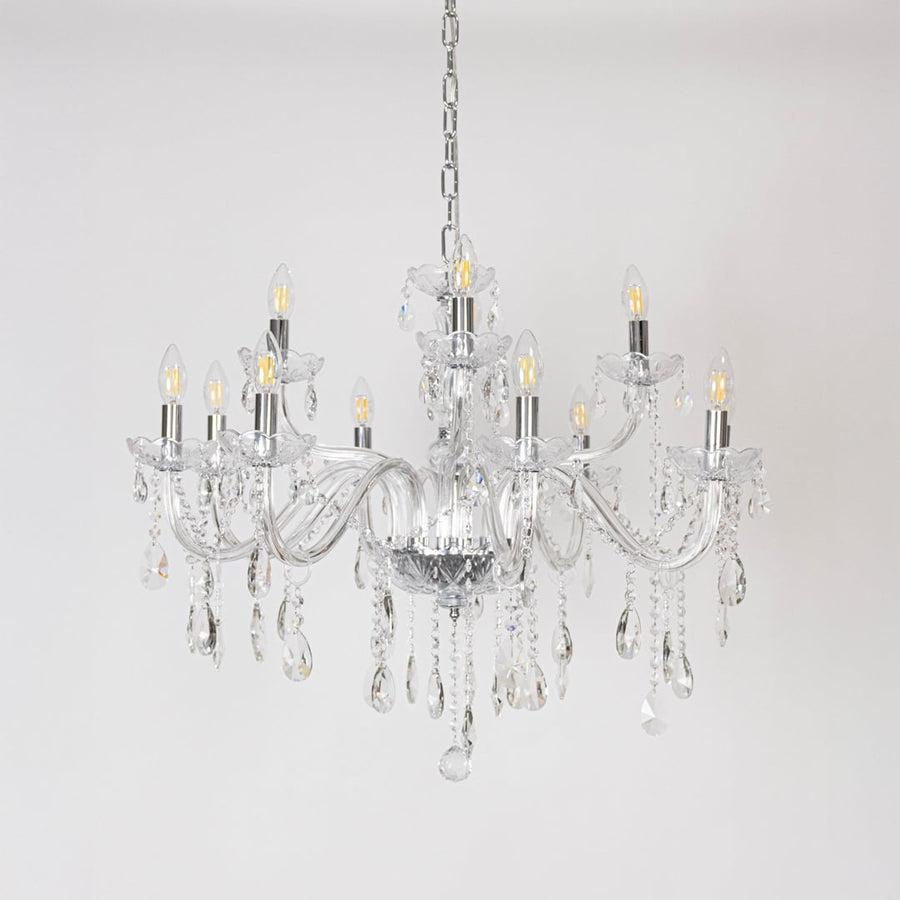 Crystal chandelier with glass arms candle lights and crystal drops turned off on white background decor.