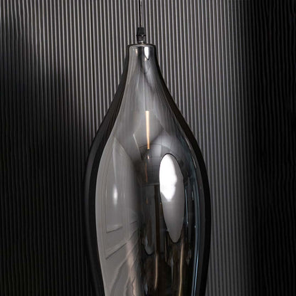 A closeup view of the smoked black pendant light showing the smooth curved glass surface and warm reflective glow ideal for premium interiors.