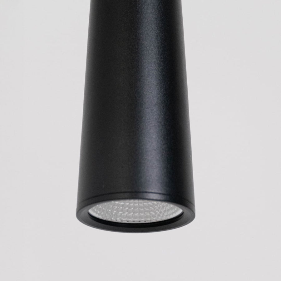 Closeup of sleek black cone pendant light in durable metal with smooth matte finish for modern bedroom or living room lighting.