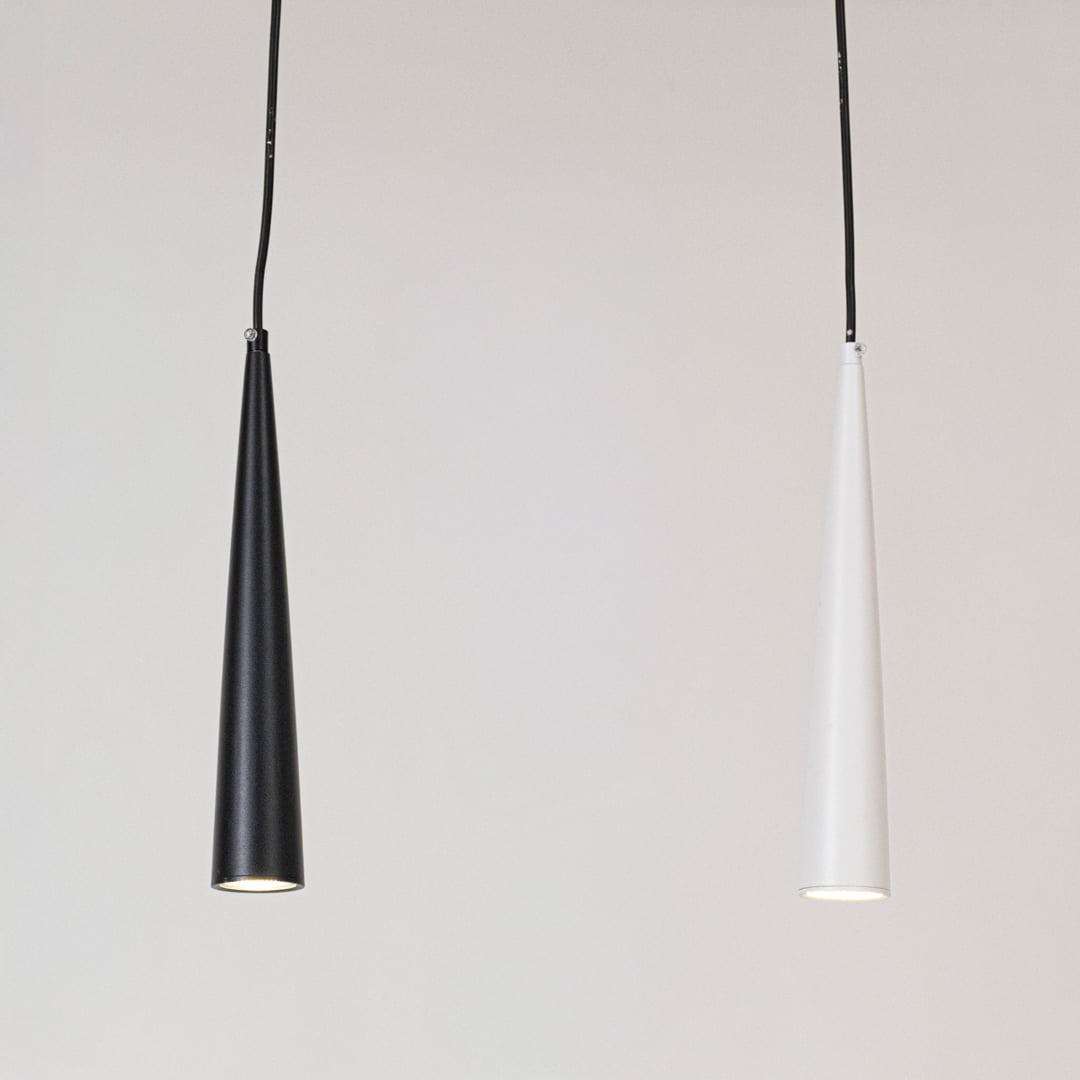 Sleek black and white cone shaped pendant lights glowing elegantly on a white background for home decor.
