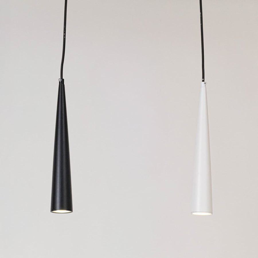 Sleek black and white cone shaped pendant lights glowing elegantly on a white background for home decor.