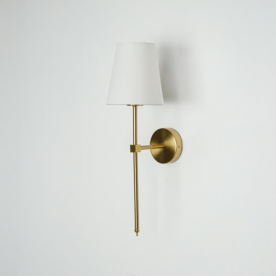 Minimal wall light in gold metal finish with fabric shade for bedroom or living room decor lighting white background.
