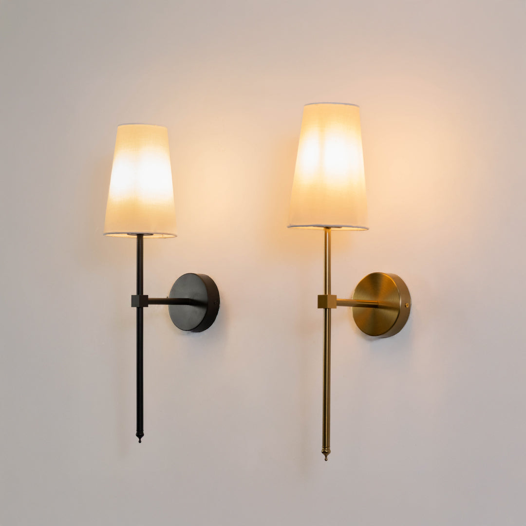 Modern wall light set in black and gold metal finish with fabric shades for bedroom or living decor lighting placement white background.