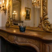 Blue bubble glass vase styled on a wooden table adding a touch of coastal charm to modern interiors.