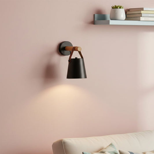 Contemporary black metal spotlight wall light enhancing cozy bedroom ambiance with warm lighting.
