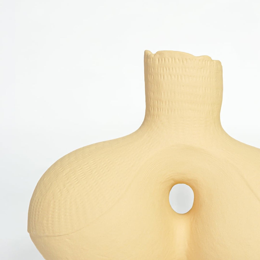 Textured beige ceramic artistic vase with rounded form for elegant console table and office decor.