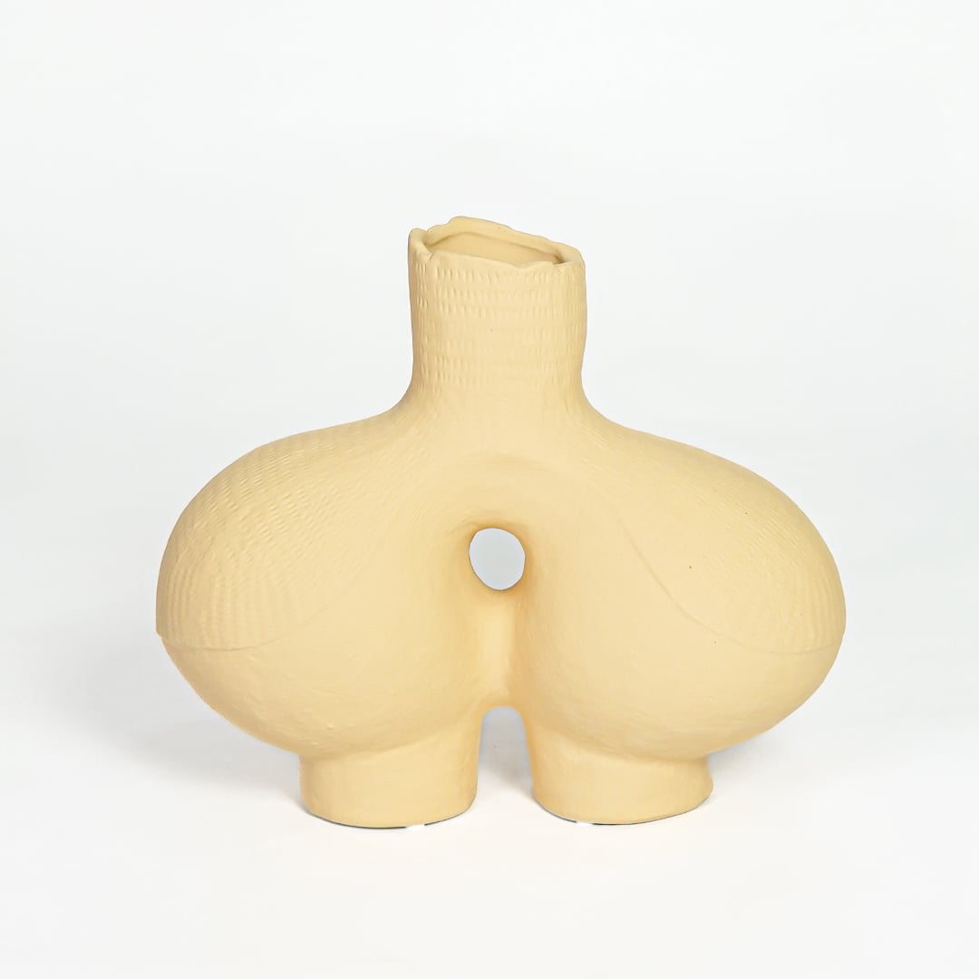 Contemporary beige ceramic decorative vase with unique hollow center for minimalist home decor styling.