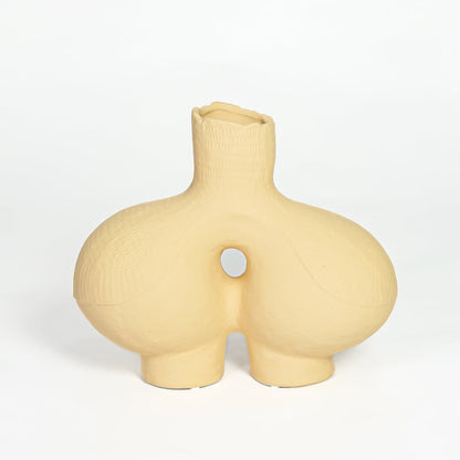 Contemporary beige ceramic decorative vase with unique hollow center for minimalist home decor styling.