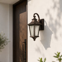 Outdoor lantern wall light mounted on a modern balcony wall illuminating a cozy rattan sofa set with green plants for a warm and stylish evening ambiance.