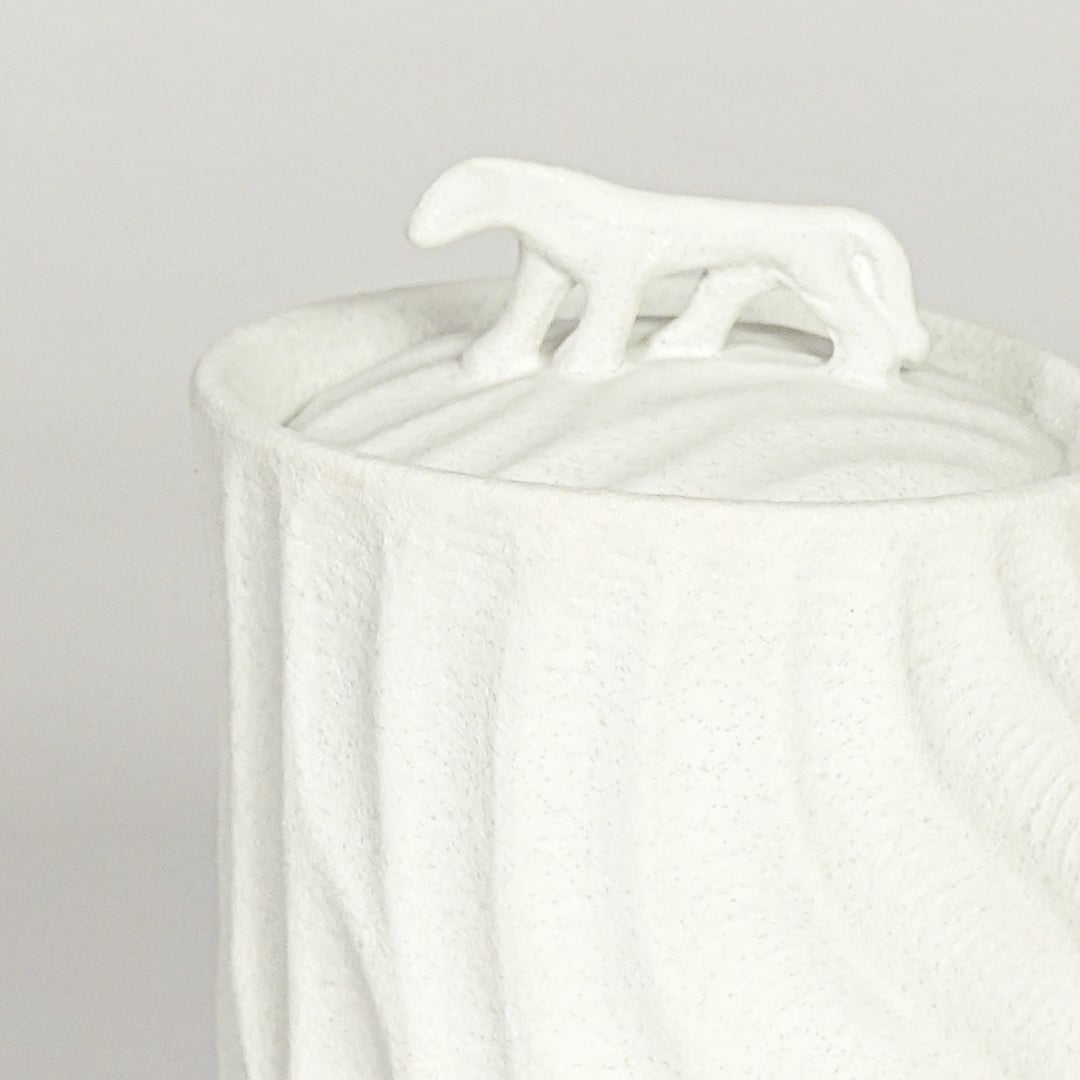 Close view of white textured ceramic jar with sculpted animal lid highlighting matte finish for table shelf or console placement.