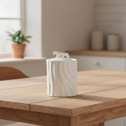 White textured ceramic decorative jar with sculpted animal lid styled on wooden table in warm modern living room setting.