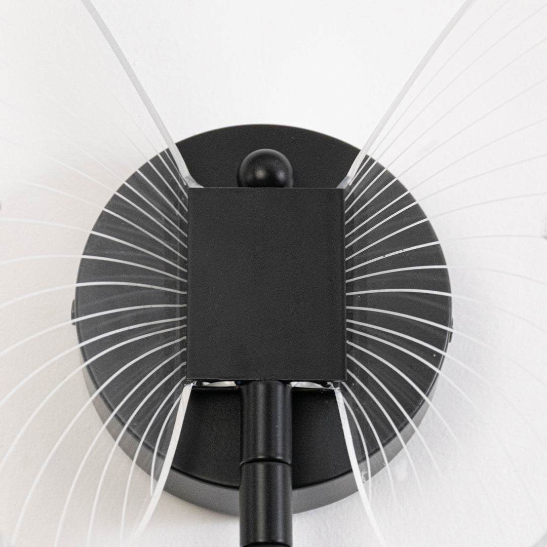 Modern wall light in black metal finish with radial design for bedroom or living room decor lighting white background.