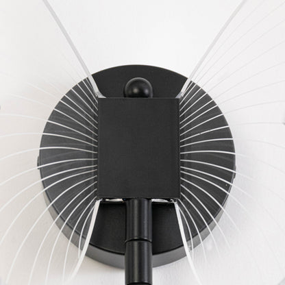 Modern wall light in black metal finish with radial design for bedroom or living room decor lighting white background.