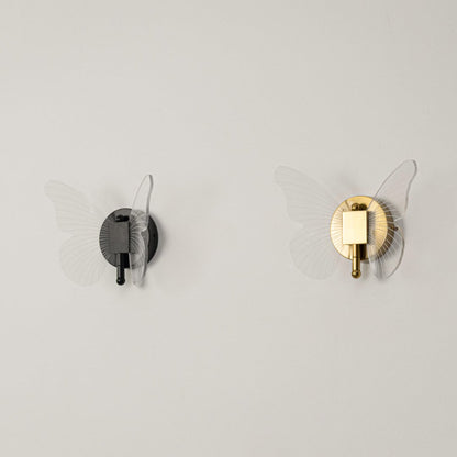 Black butterfly wall light with clear acrylic wings shown on a white background with lights off for product clarity.