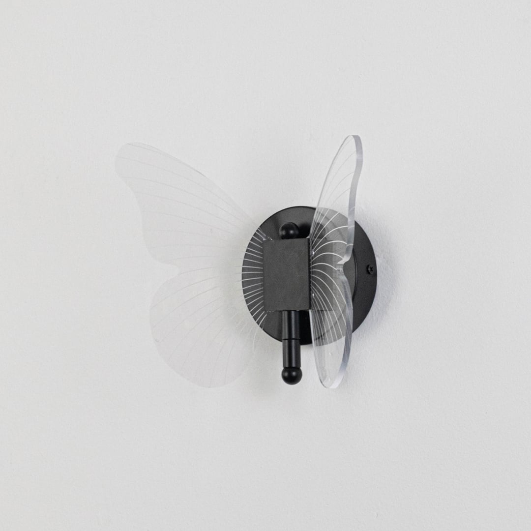 Black butterfly design wall light with clear acrylic wings shown on a plain white background for accurate detail.