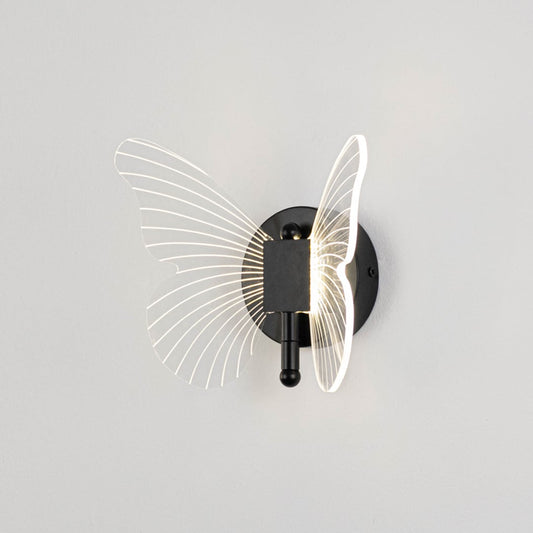Black butterfly wall light with clear acrylic wings illuminated on a bright white background for clear visibility.