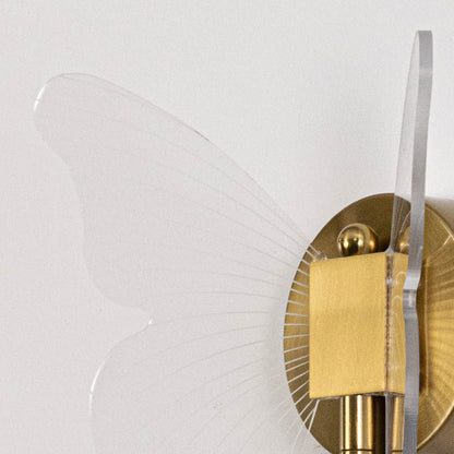 Closeup of gold butterfly wall light with clear acrylic wings showing delicate wing texture and elegant design.