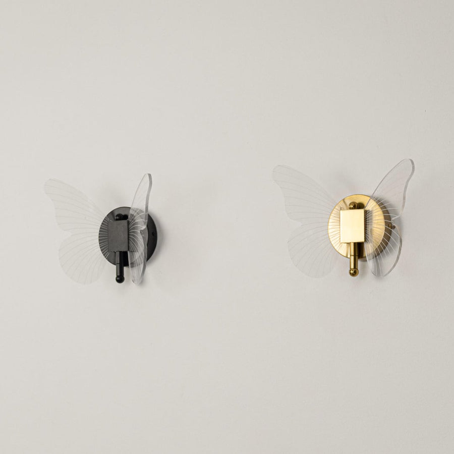 Gold butterfly wall light with clear acrylic wings shown on a white background with lights off for product clarity.