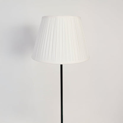 Closeup of pleated fabric floor lamp shade with elegant modern black stand.