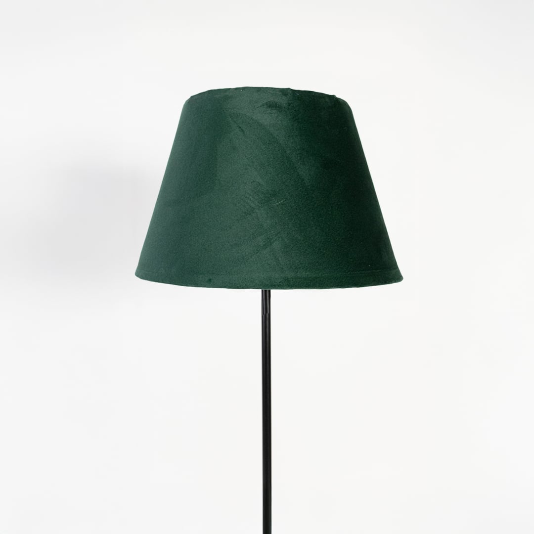 Closeup of dark green fabric shade with slim black stand floor lamp for stylish bedroom or living room lighting.