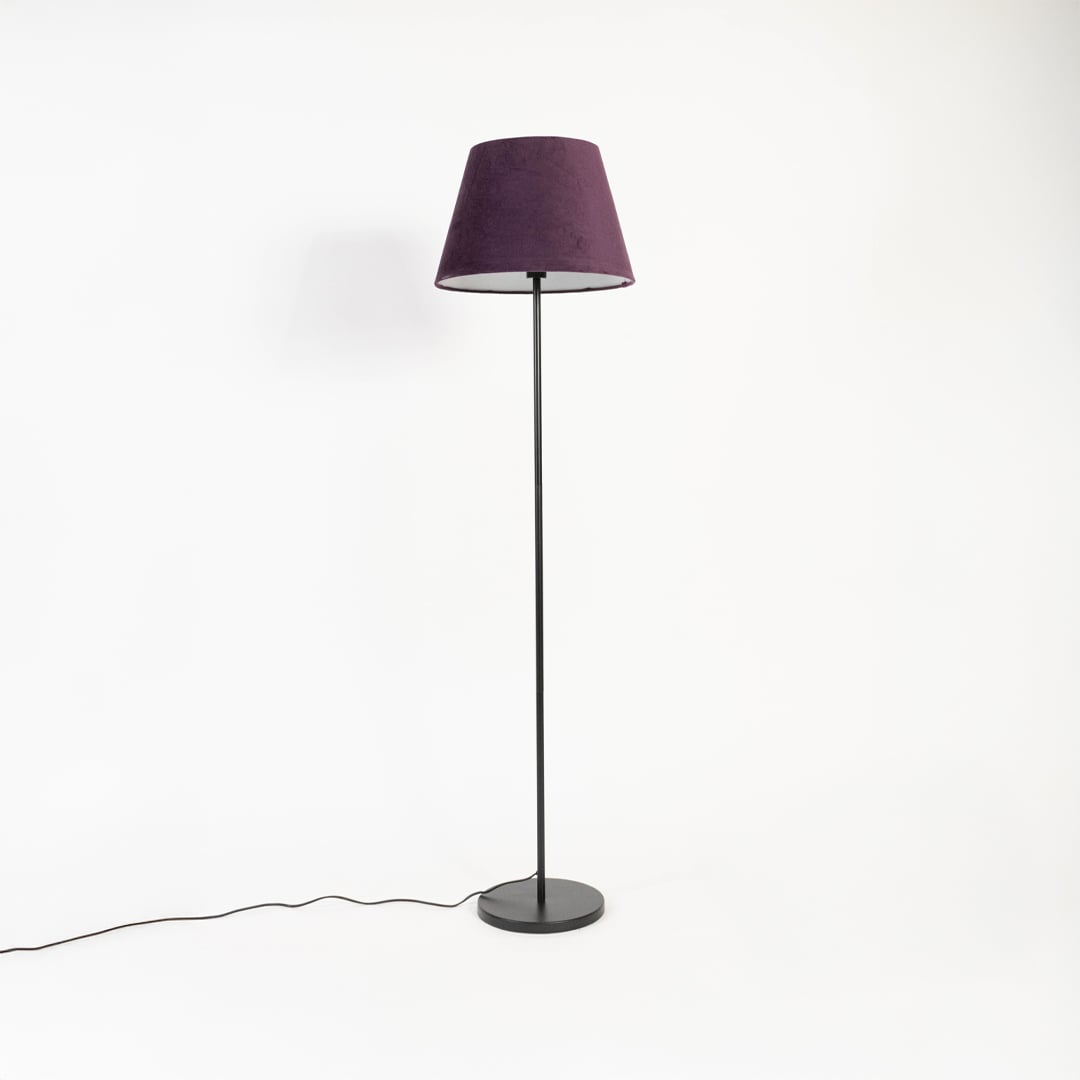 Elegant purple fabric shade floor lamp with slim black metal stand shown off on white backdrop.