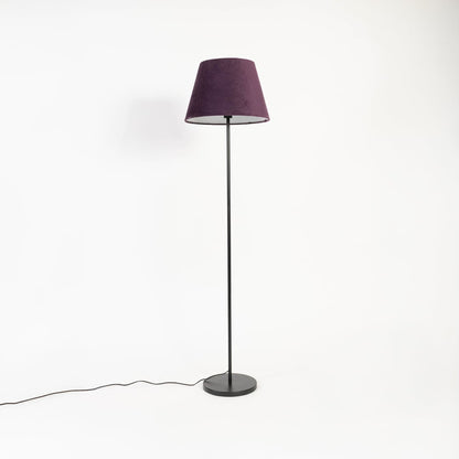 Elegant purple fabric shade floor lamp with slim black metal stand shown off on white backdrop.
