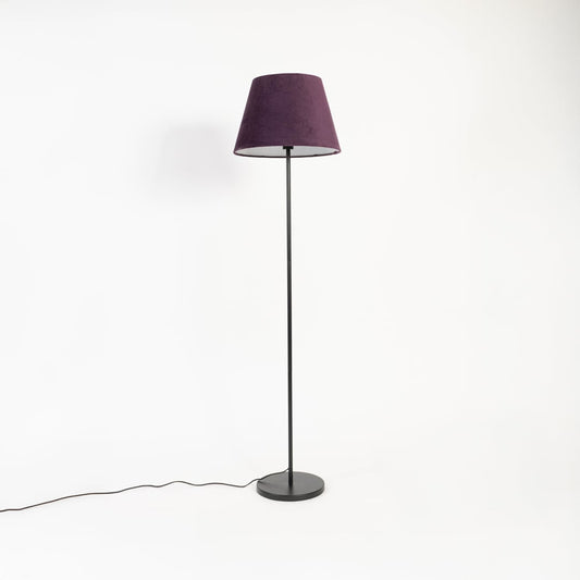 Elegant purple fabric shade floor lamp with slim black metal stand shown off on white backdrop.