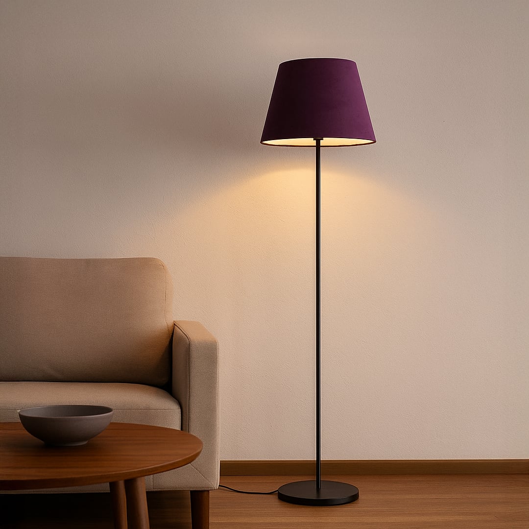 Purple fabric shade floor lamp with slim black metal stand styled in modern living room beside sofa.
