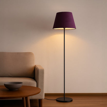 Purple fabric shade floor lamp with slim black metal stand styled in modern living room beside sofa.