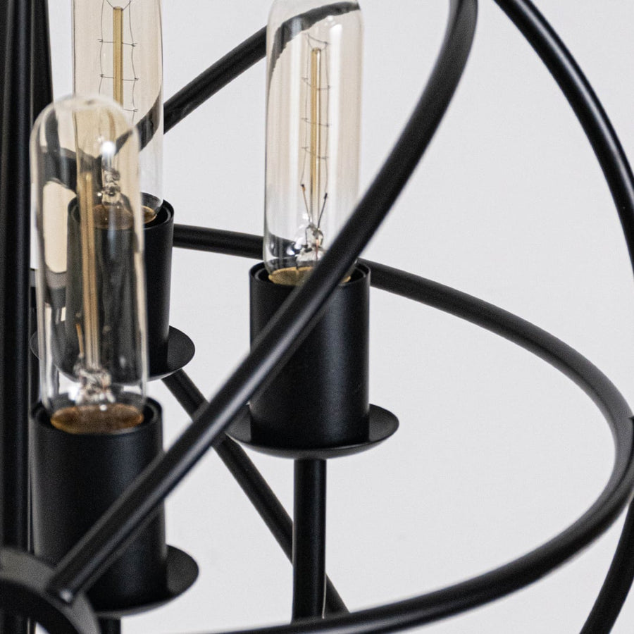 Closeup of black chandelier with circular open frame and visible filament bulbs for stylish modern ceiling lighting.