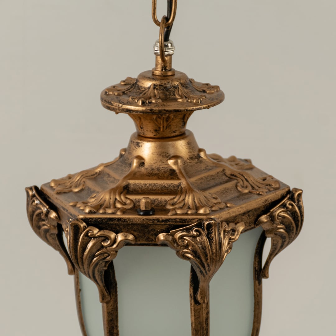 Detailed closeup view of antique brass metal finish and texture of frosted glass panels on this classic outdoor hanging lantern.