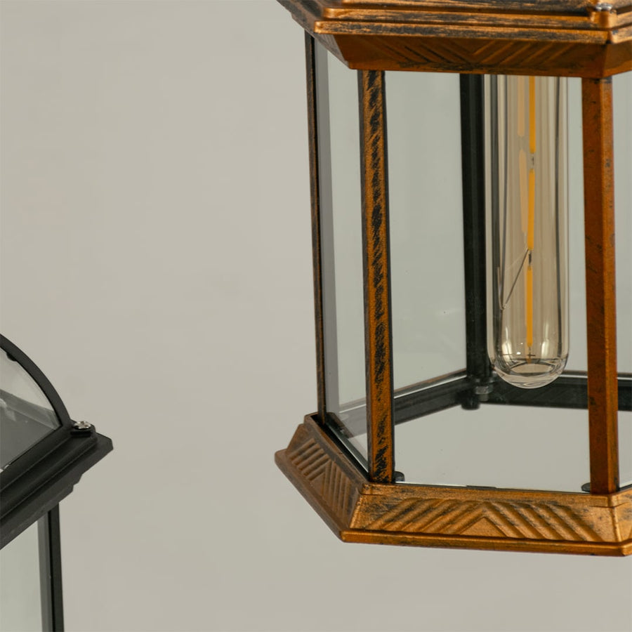 Close view of lantern turned off with highlighting bronze antique finish clear glass panels and vintage inspired hanging chain design.